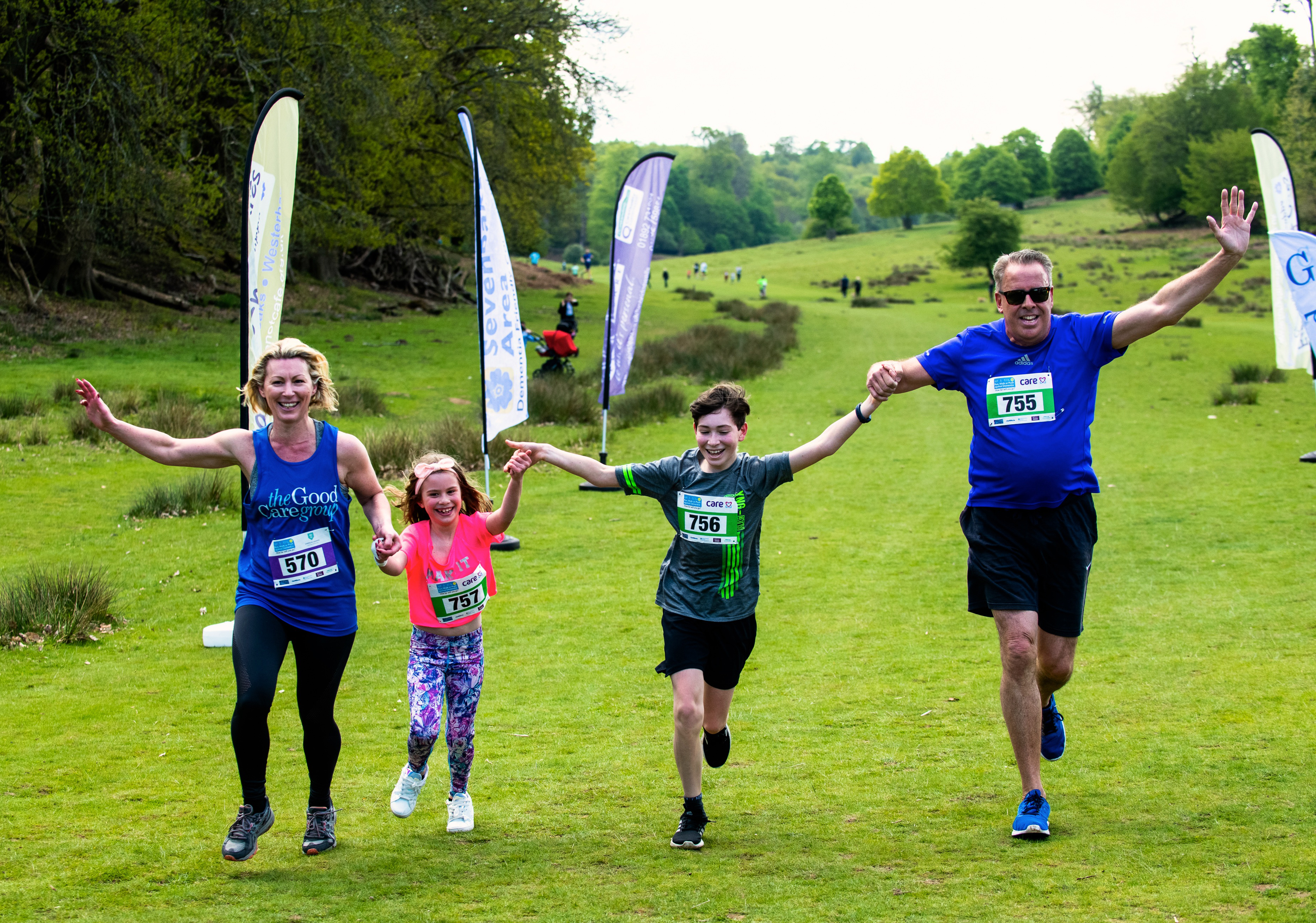 Family of two adults and two children crossing the finishing line at the 2019 event